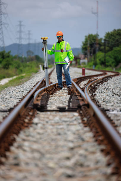 istock Engineer wearing hard hats and uniforms use theodolite equipment surveying construction worker on Railway site. 1649704368