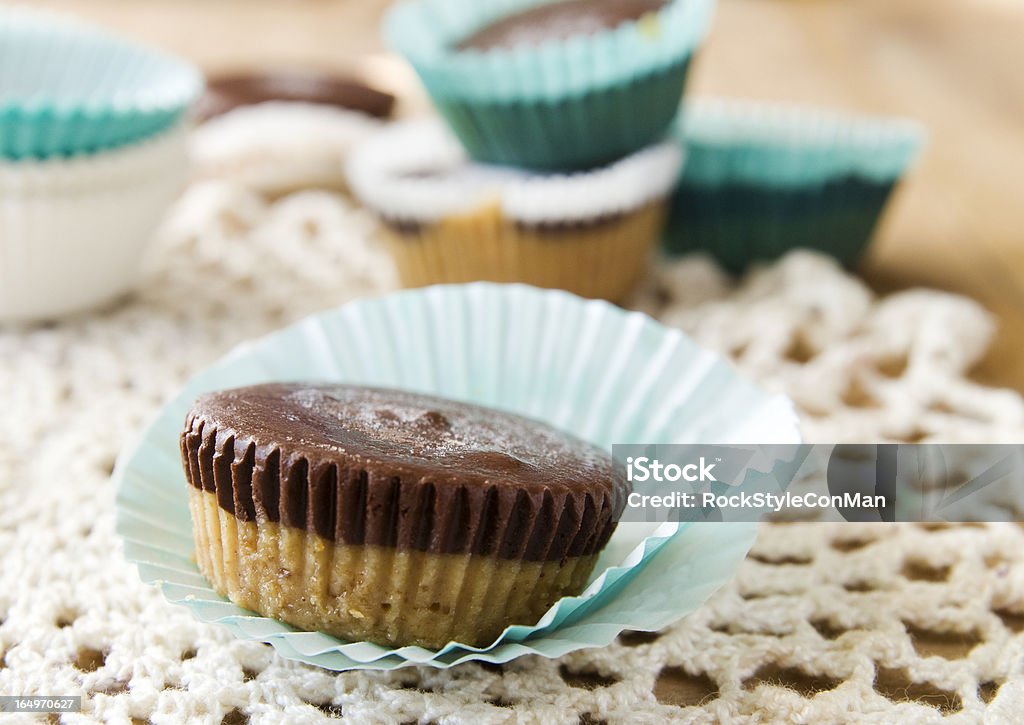 Peanut Butter Cups Organic Peanut Butter Cup sitting in the lower left third of the frame. Horizontal orientation, lace doily and rustic wood table. Chocolate Stock Photo