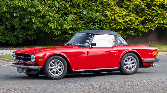 Whittlebury,Northants,UK -Aug 27th 2023: 1972 red Triumph TR6 car travelling on an English country road