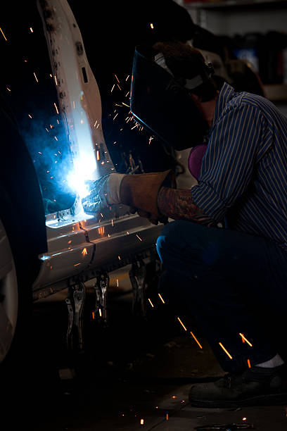 istock Shop worker welds door frame of an automobile 164972283