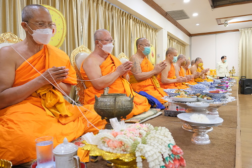 11/07/2019 Shwedagonm pagoda, Yangon, Myanmar\nSenior monk in orange traditional buddhist dress walking inside the temple on white marble floor