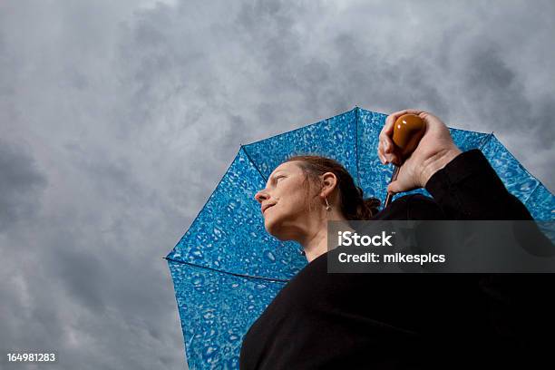 Photo libre de droit de Faible Angle De Femme Avec Parapluie Regardant Sur Le Temps Orageux banque d'images et plus d'images libres de droit de Examiner