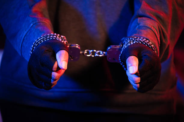 istock Men with handcuffs in front on black background.close-up view 1649820537