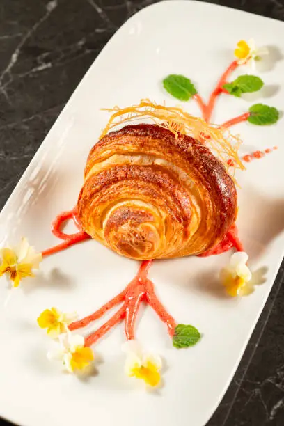 Close-up of crispy, flaky, and delicious butter croissant coated in cinnamon sugar.