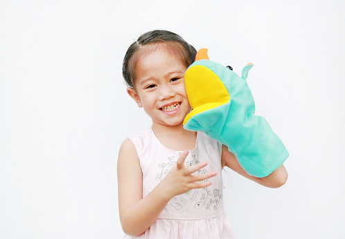 Smiling little Asian child girl hand wear and playing Rhinoceros puppets on white background. Educations concept.