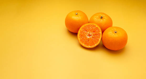 istock Pile of fresh oranges on a yellow background with copy space for text 1649875722
