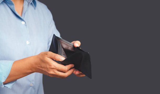 istock Close-up of hands man opening an empty wallet while standing on a gray background 1649877303