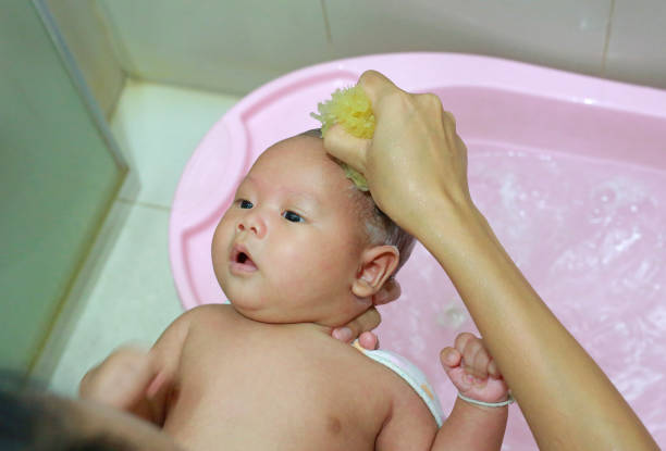 istock Six month old Asian infant boy having a bath by mother. 1649920696