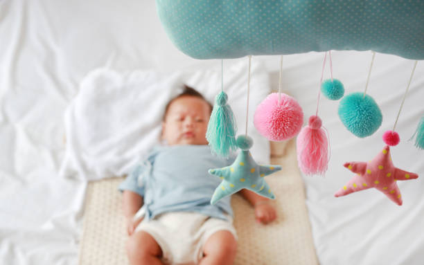 istock Baby mobile with infant looking on the bed. 1649921076