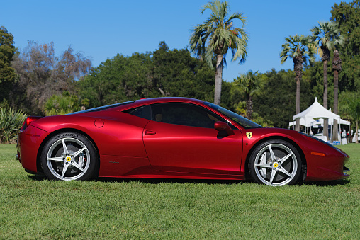 San Marino, California, United States: modern Ferrari 458 Italia shown parked on grass at Lacey Park on a sunny afternoon. Car designed by Donato Coco in collaboration with Pininfarina.