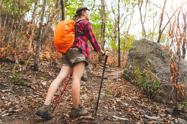 femme de randonneur avec des bâtons de trekking monte raide sur le sentier de montagne, foyer sur la botte - success determination idyllic carefree photos et images de collection