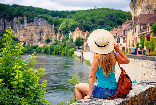 Woman traveling in France, Dordogne river and village of La Roque-Gageac
