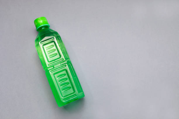 Top View Green Ribbed Plastic Bottle With Liquid, Aloe Juice On Grey Background. Copy space for text, horizontal plane. Healthy Bio Beverage. High quality photo