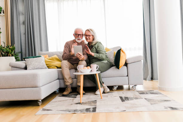 istock Senior retired couple using digital tablet and enjoy talking conversation together on sofa with happiness laugh smile and joyful at home 1649947912