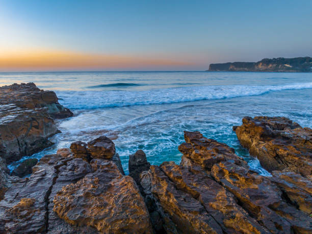 istock Sunrise over the ocean and rock platform with clear skies 1649988023