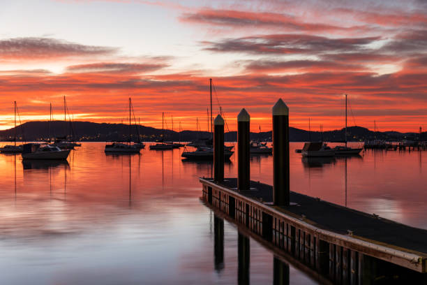 istock Sunrise over the water with boats, reflections and high cloud 1649995306