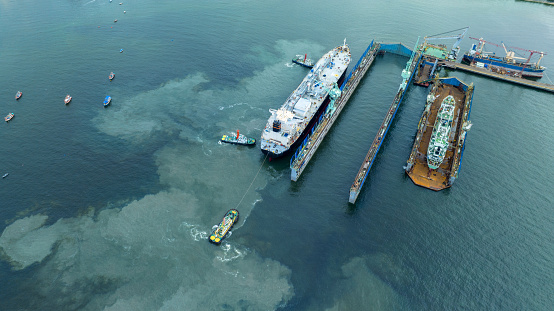 cargo container ship at dry dock concept maintenance service working in the sea. Insurance and Maintenance Cargo Ship concept. Freight Forwarding Service maintenance Insurance