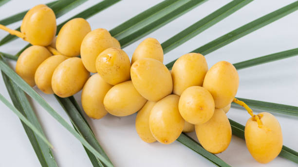 istock Fresh dates, yellow fruits on green leaves 1650059728