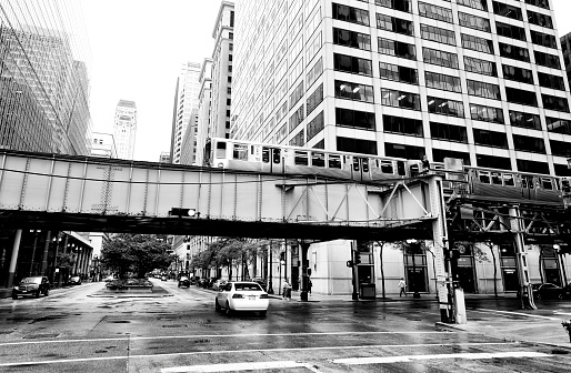 Chicago Loop elevated train crossing LaSalle street between urban buildings, Illinois, USA.