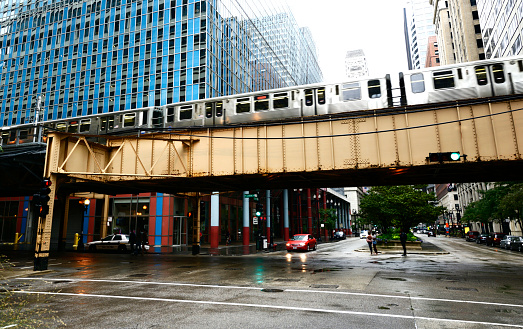 Chicago Loop elevated train crossing LaSalle street between urban buildings, Illinois, USA.
