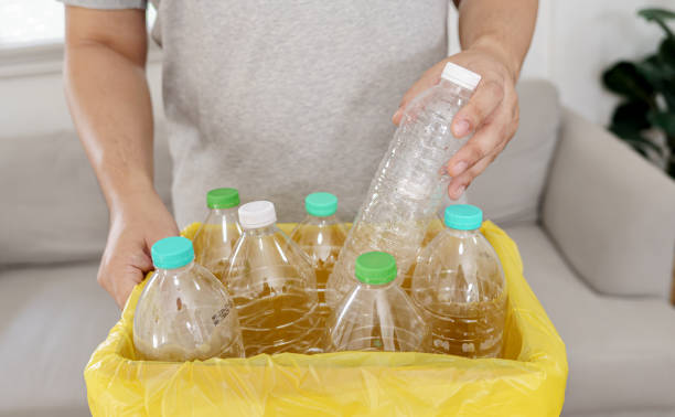 istock Home recycle eco green zero concept Man throwing empty plastic bottle in recycling bin with yellow garbage bags at home 1650117927