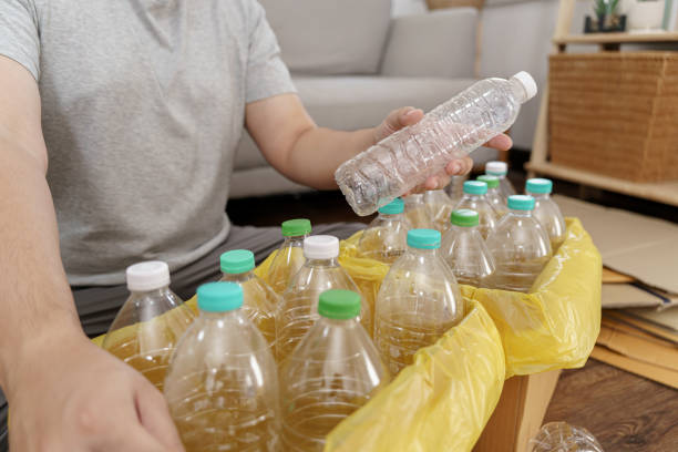 istock Home recycle eco green zero concept Man throwing empty plastic bottle in recycling bin with yellow garbage bags at home 1650117936