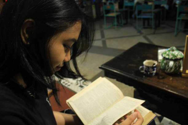istock attractive woman reading a book in vintage coffeshop 1650123269