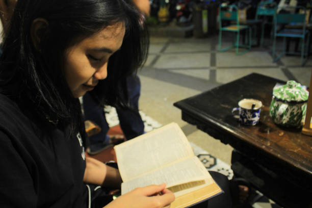 istock attractive woman reading a book in vintage coffeshop 1650123280