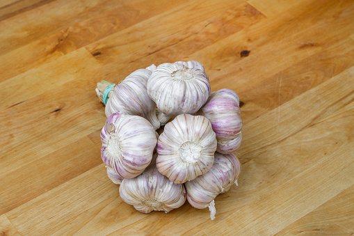 A bunch of garlic heads on a wooden kitchen counter, isolated