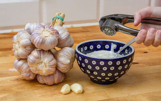 Press the garlic through a press directly into the bowl with the sauce
