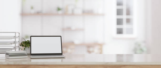 istock A white screen laptop mockup on a tabletop with a blurred modern white room in the background. 1650125834