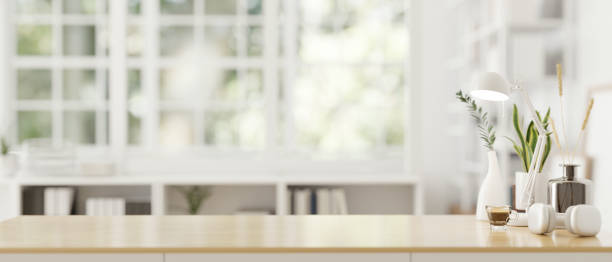 istock Mockup space on a wooden tabletop with a blurred modern white room in the background. 1650125835