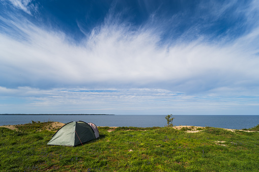 Wild camping in nature in Estonia in summer. Tent on the steep shore of the Baltic Sea in Paldiski. High quality photo