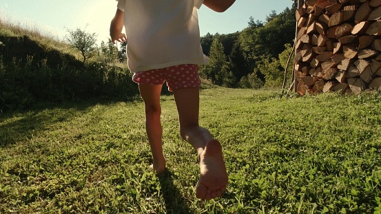 Young Girl Running Barefoot on Farm Grass at Sunset Slow Motion