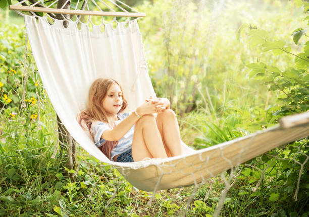 istock A little girl rests in a hammock and eats cherries in the summer. 1650146421