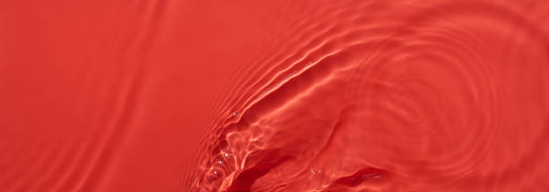 Water red surface abstract background. Waves and ripples texture of cosmetic aqua moisturizer with bubbles