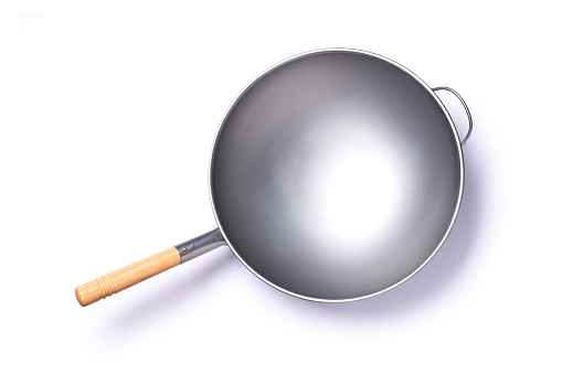 Empty iron frying pan with wooden handle isolated on white background with clipping path, top view, flat lay.