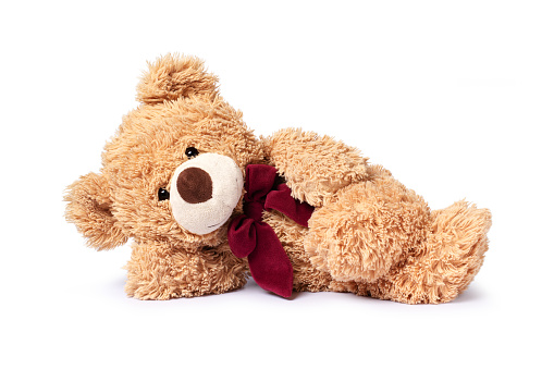 Brown teddy bear reclining isolated on white background