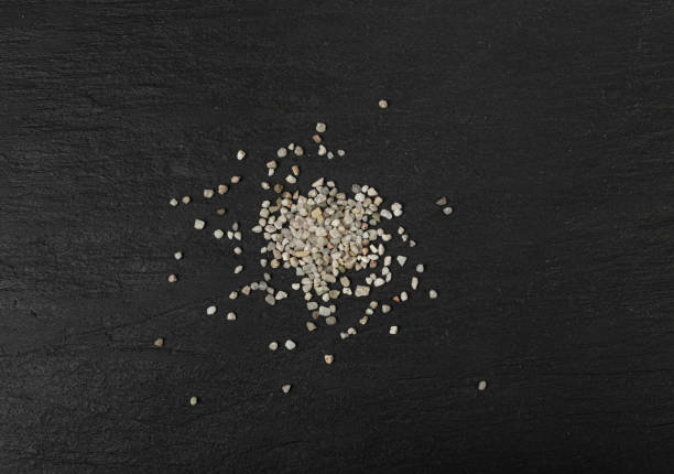 istock Crushed Quartz Pile, White Stone Pieces, Grit Sand, Decorative Rocks Texture on Black Background 1650172789