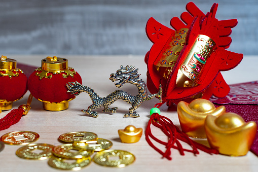 Chinese new year decorations and gold ingots or golden lump on wooden background. Still life.