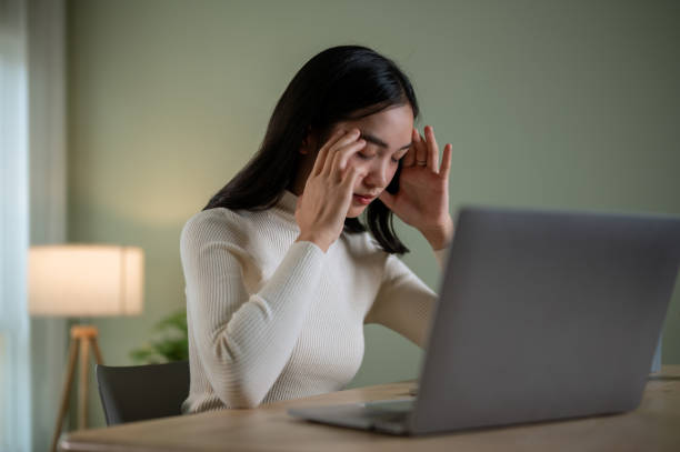istock A thoughtful Asian woman is feeling stressed, tired and headache-ridden while working 1650204084