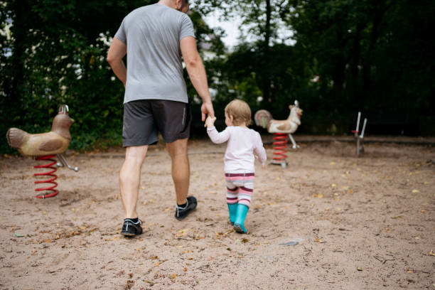 istock a child playing in the playground with his father 1650212720