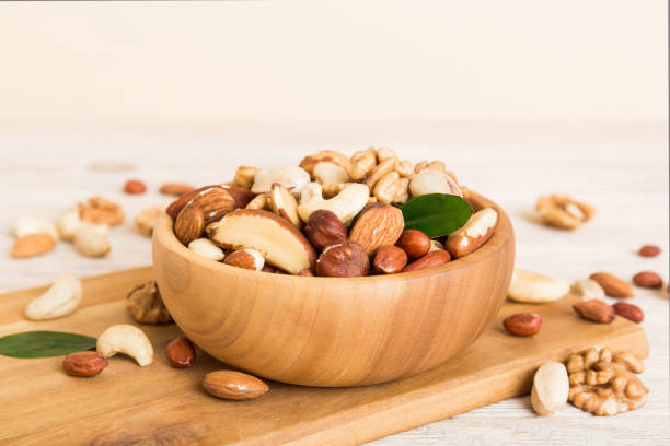 istock mixed nuts in bowl. Mix of various nuts on colored background. pistachios, cashews, walnuts, hazelnuts, peanuts and brazil nuts 1650221556