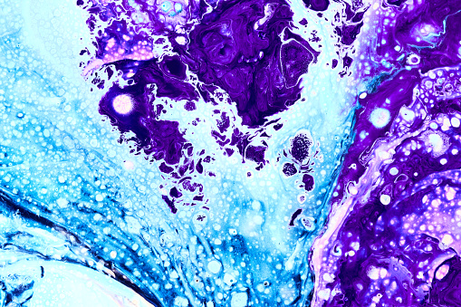 Photo of blue and purple flowing paint texture. Marbled paper abstract background