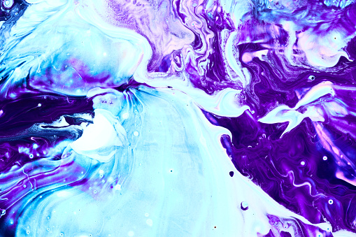 Photo of blue and purple flowing paint texture. Marbled paper abstract background