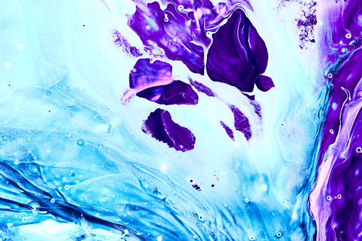 Photo of blue and purple flowing paint texture. Marbled paper abstract background