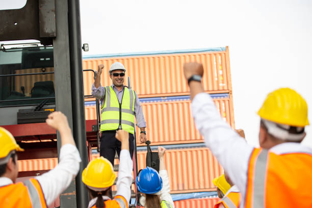 istock Logistic manager giving public speech and showing support to construction worker at container warehouse. Leader announcing good news. Successful corporate people and business. 1650228958