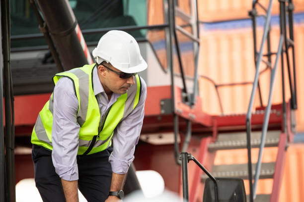 istock Logistic foreman standing on forklift truck at container warehouse distribution. Export import business concept 1650228992