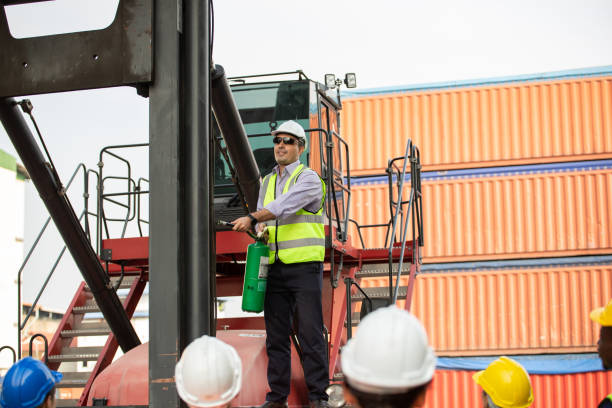 istock Manager training and showing staff worker to use fire extinguisher at the construction site. Man standing or forklift truck and explain to employee 1650229507