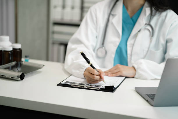 istock female medical doctor's hands write a note and use tablet working. Doctor's working place. Healthcare and medical concept. 1650236334
